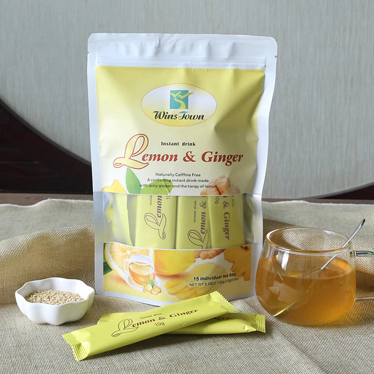 Wiss Town Lemon & Ginger instant drink package with a cup of tea and ingredients on a textured surface.